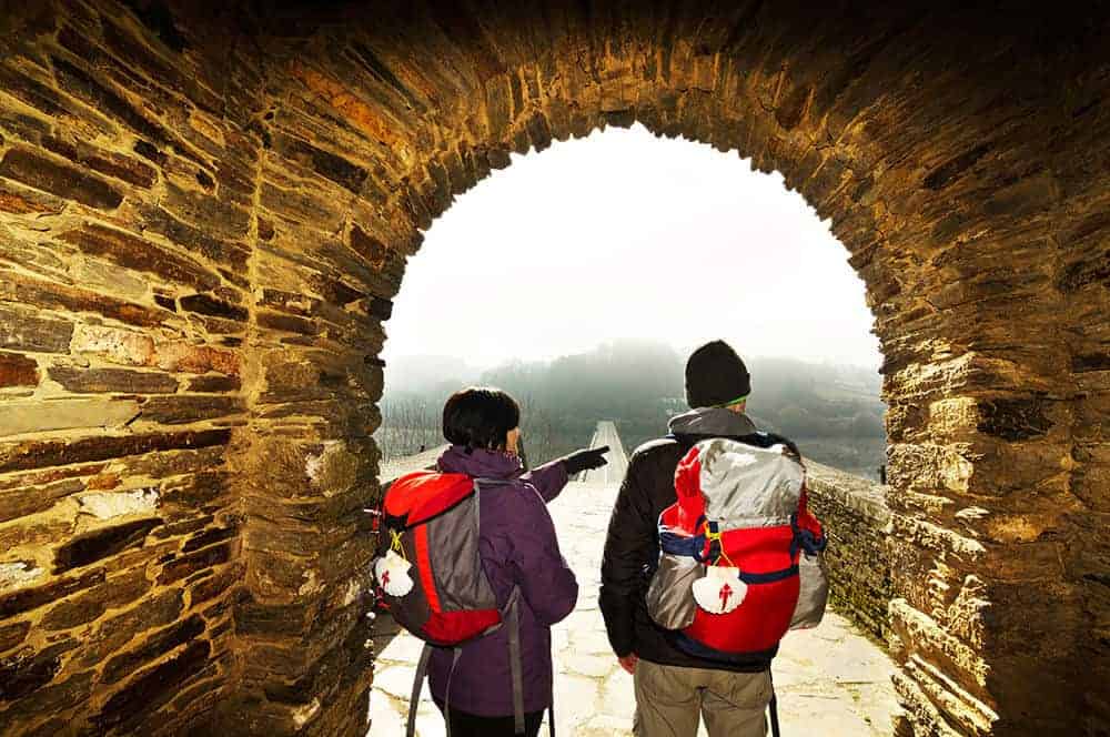 Romantic couple on the camino de santiago under the arch
