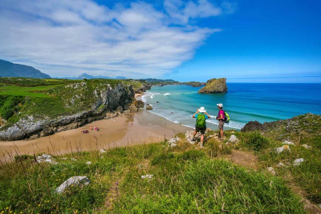 pilgrims on the camino del norte looking at san martin beach