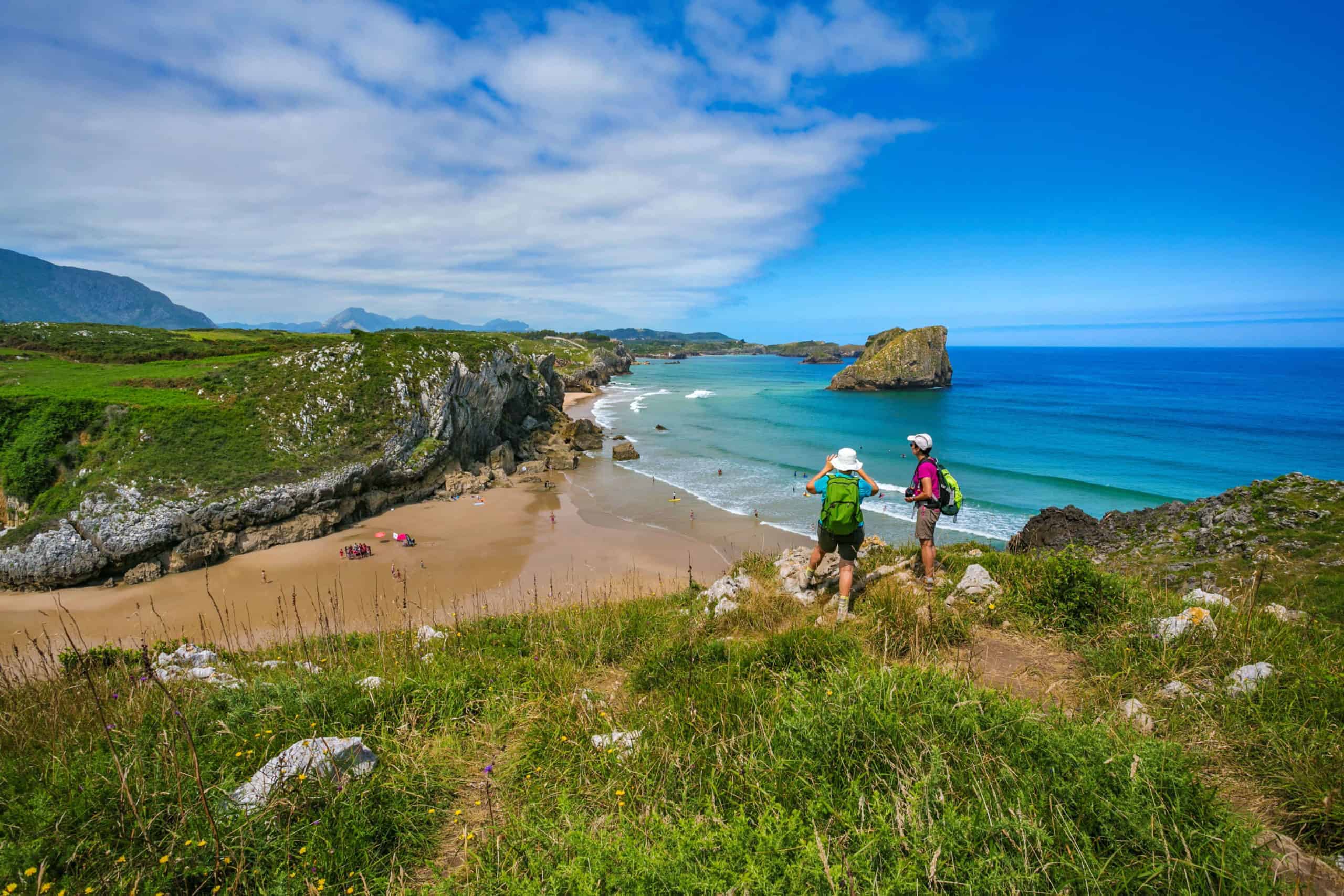 pilgrims on the camino del norte looking at san martin beach