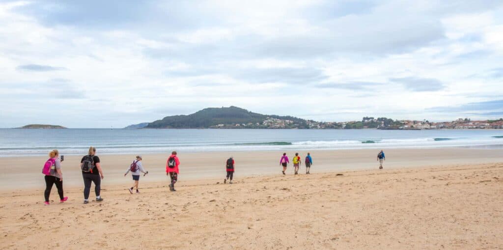 Pilgrims walking the beach on the Camino portugues