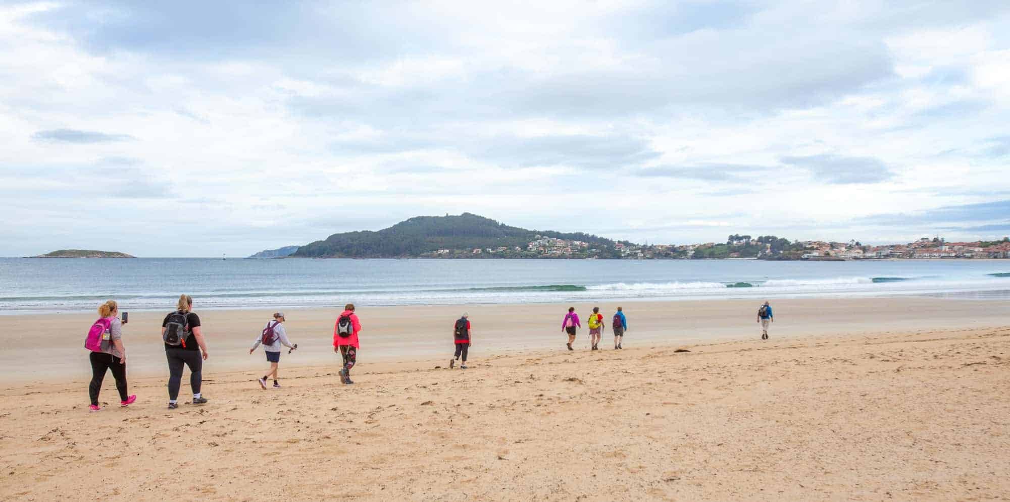 Pilgrims walking the beach on the Camino portugues