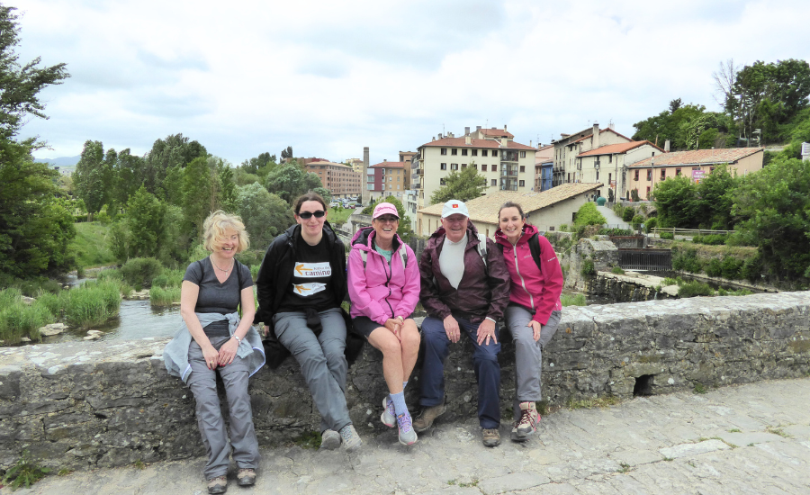 group of pilgrims posing by bridge