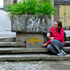 Yellow arrow with girl sitting next to it in porto