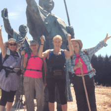 Pilgrims posing in front of statue Camino Frances