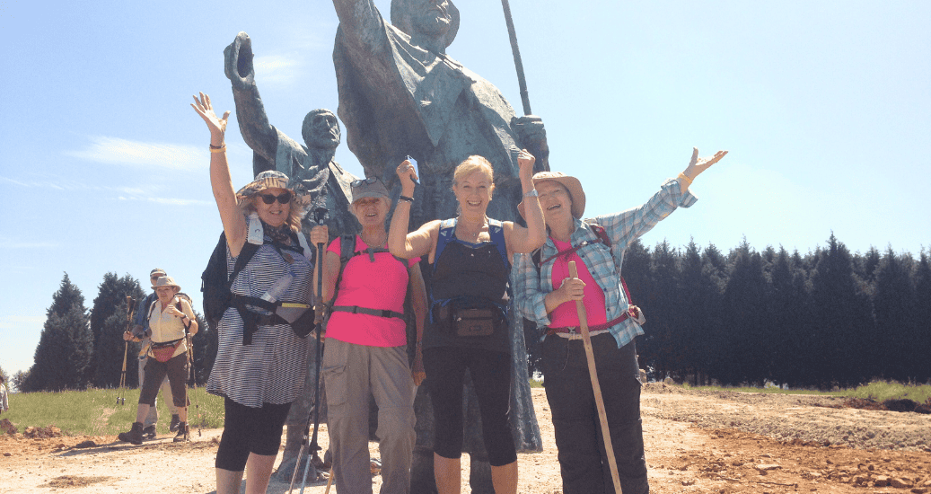 Pilgrims posing in front of statue Camino Frances