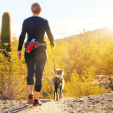 Woman with dog on sunny path
