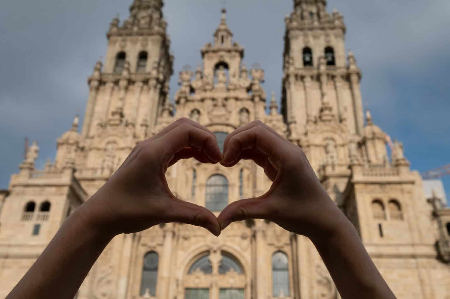 Pilgrim making a love heart sign at the Cathedral de Santiago
