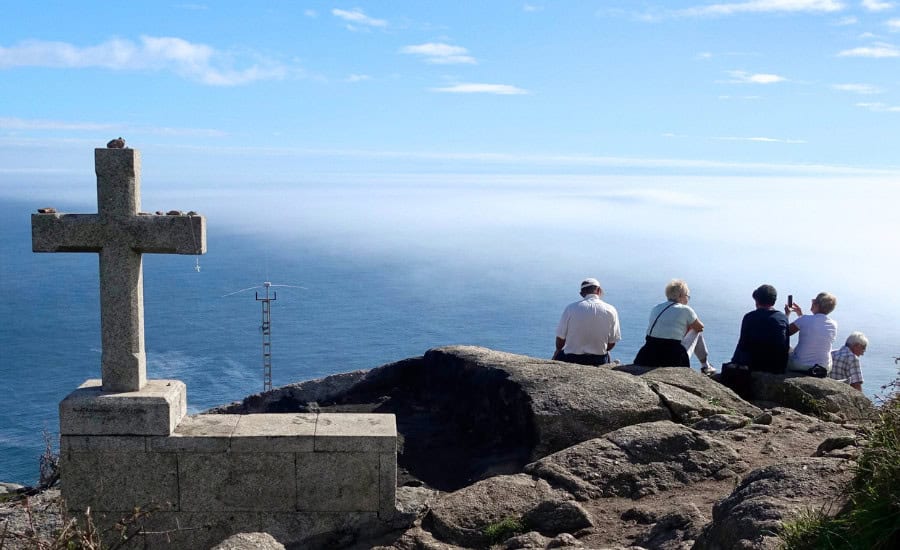Pilgrims sitting by Fisterra