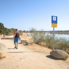 Pilgrim walking by camino de santiago sign