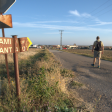 Pilgrim walking by camino de santiago sign