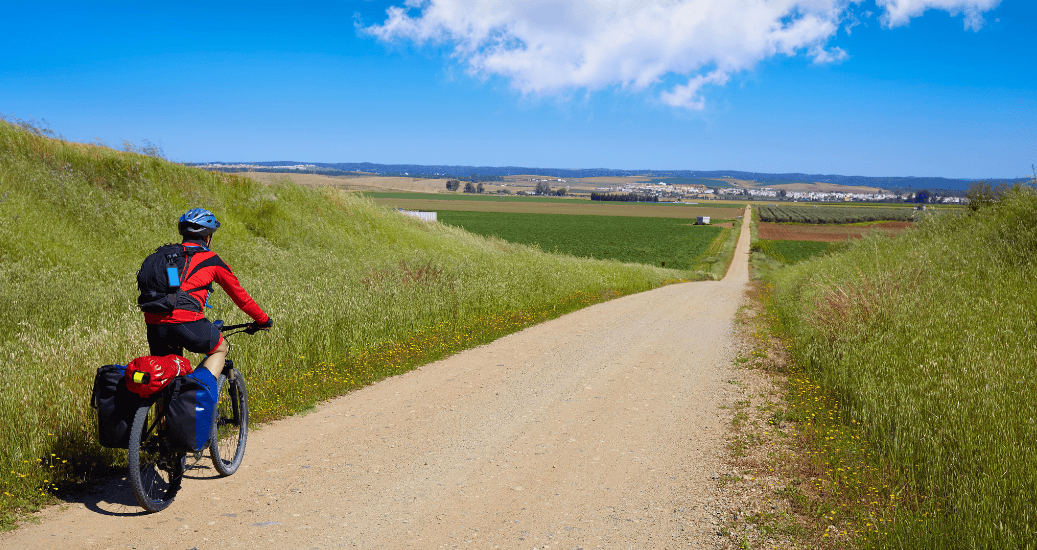 Pilgrim cycling the Camino Frances through hilly region