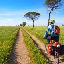 Pilgrim cycling through green field camino frances