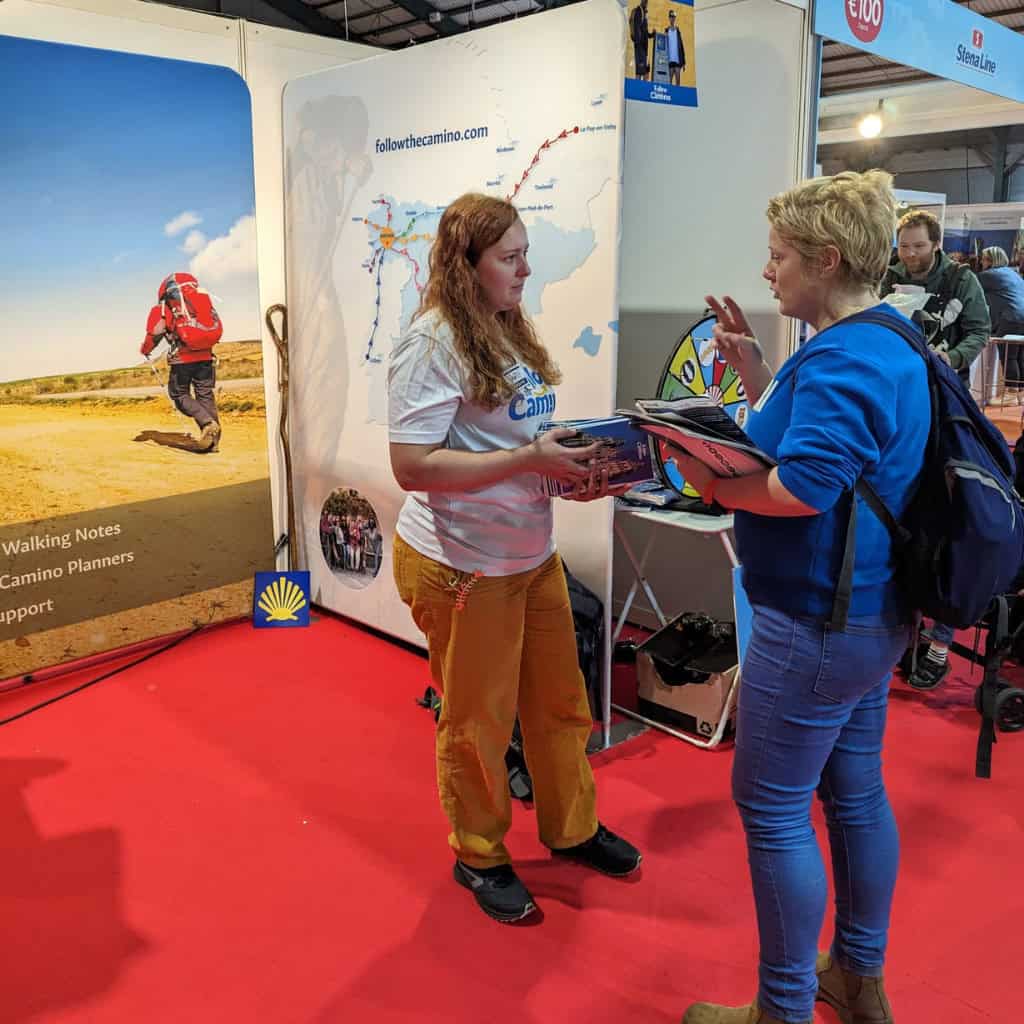 Follow the camino employee explaining client about different camino routes