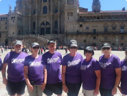 Purple house foundation group posing by cathedral de santiago