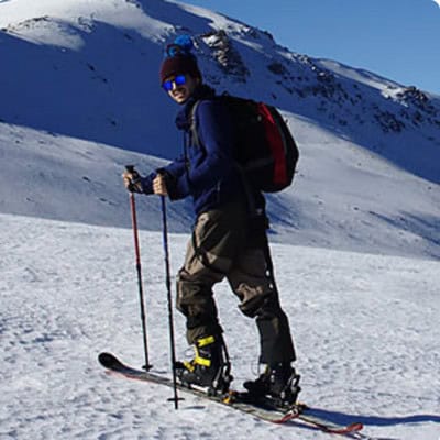 Man posing on snow capped mountains with ski