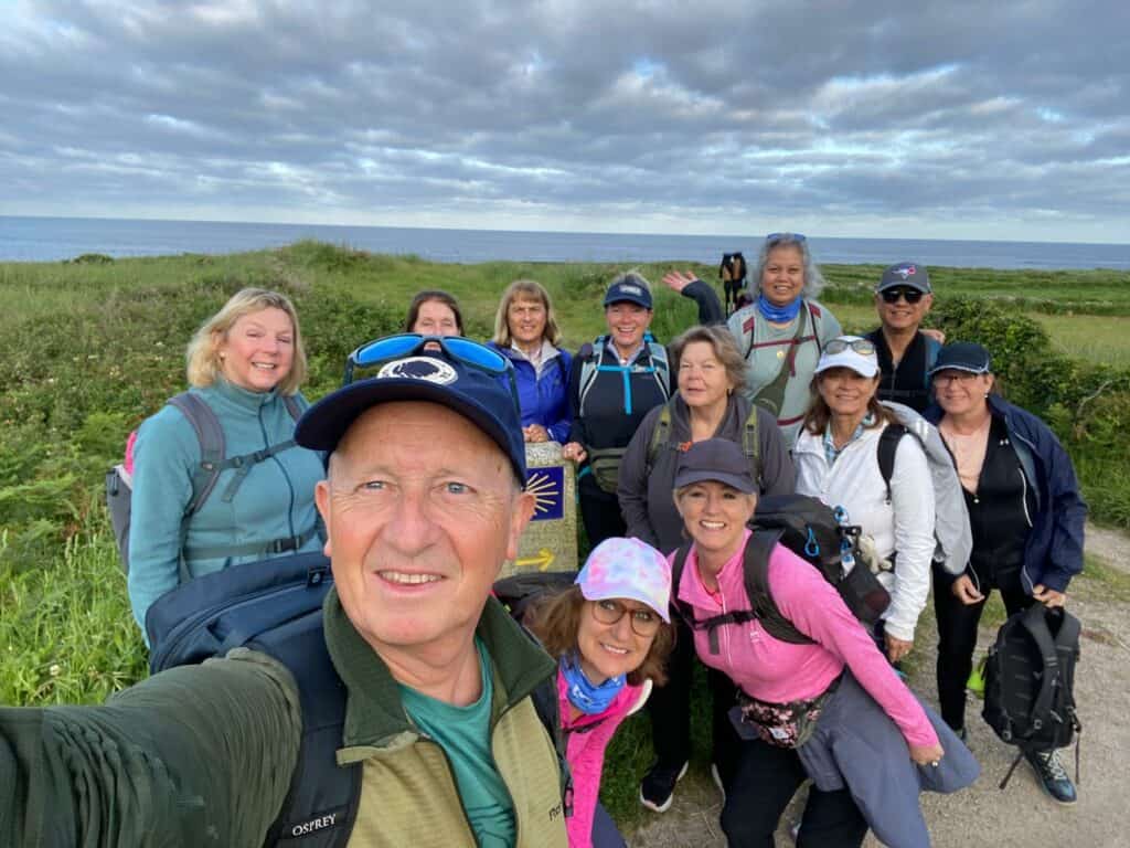 guided group photo of pilgrims by yellow arrow