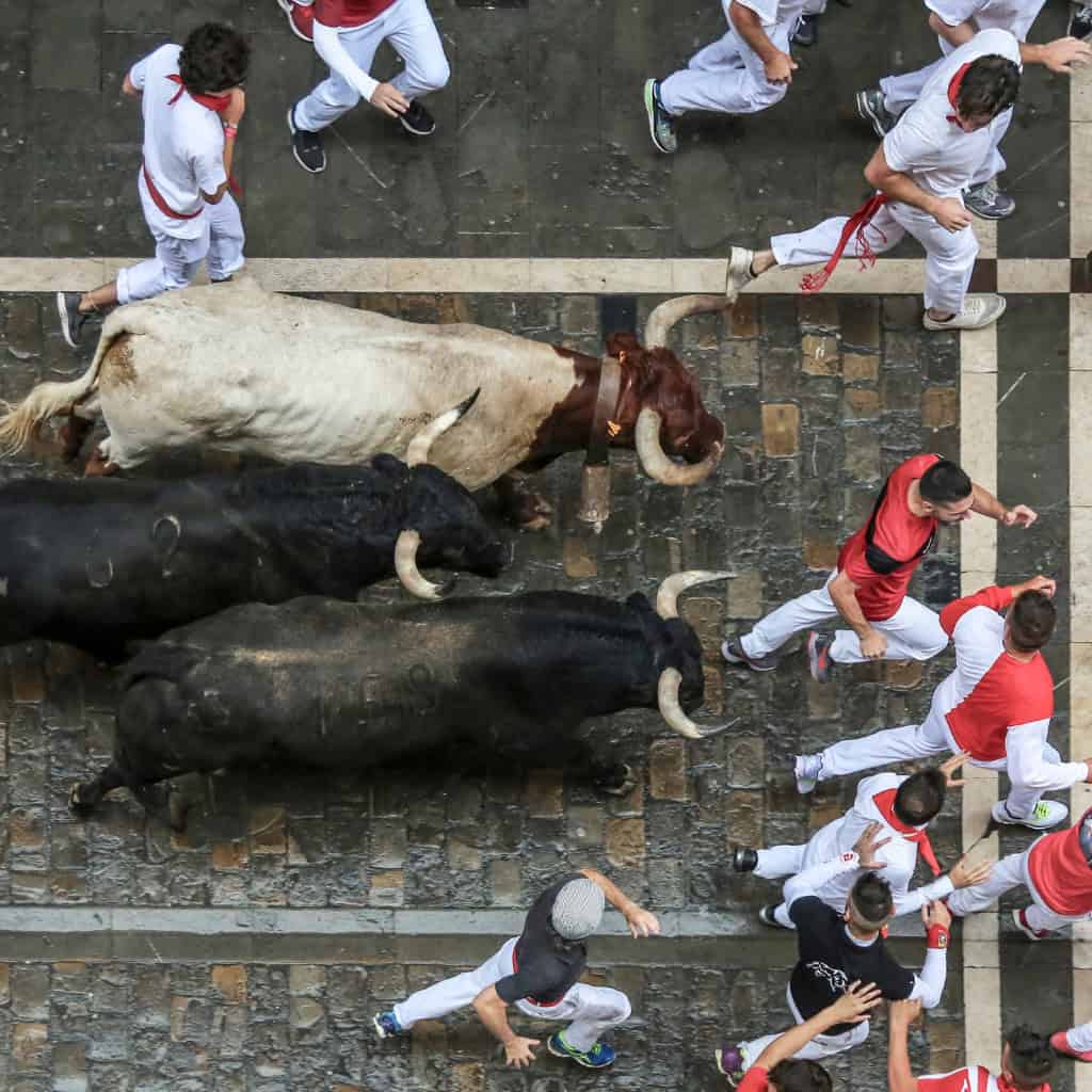 People running with the bulls during san fermin festival in Pamplona